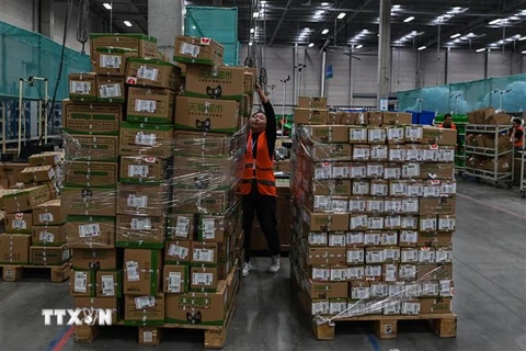 Nhân viên kiểm hàng để giao cho khách hàng tại trung tâm dịch vụ của Alibaba ở Vô Tích, tỉnh Giang Tô, Trung Quốc. (Ảnh: AFP/TTXVN)