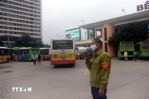 Các bến xe cử người nhắc người dân đeo khẩu trang khi vào bến. (Ảnh: Nguyễn Văn Cảnh/TTXVN)