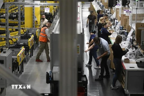 Nhân viên làm việc tại trung tâm phân phối của Amazon. (Ảnh: AFP/TTXVN)