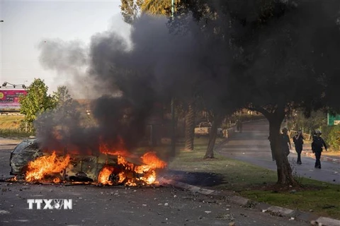 Xe cảnh sát bị đốt cháy tại thành phố Lod, gần Tel Aviv, Israel. (Ảnh: AFP/TTXVN)