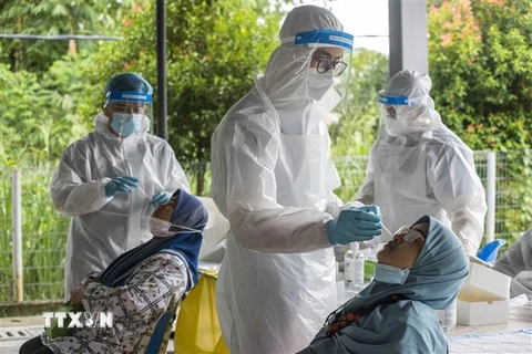 Nhân viên y tế lấy mẫu xét nghiệm COVID-19 cho người dân tại Ampang, gần Kuala Lumpur, Malaysia. (Ảnh: THX/TTXVN)