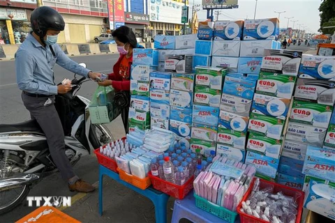 Một quầy hàng ven đường bán khẩu trang và nước sát khuẩn tại Phnom Penh, Campuchia. (Ảnh: AFP/TTXVN)