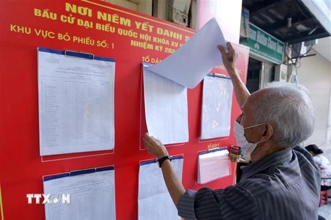 Người dân phường Hàng Bạc xem danh sách cử tri. (Ảnh: Hoàng Hiếu/TTXVN)