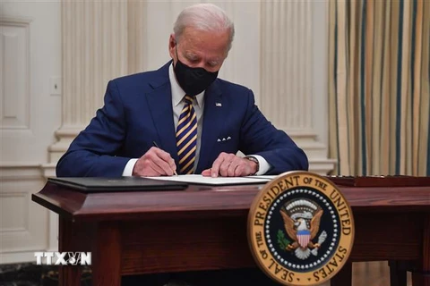 Tổng thống Mỹ Joe Biden ký sắc lệnh tại Nhà Trắng ở Washington DC. (Ảnh: AFP/TTXVN)
