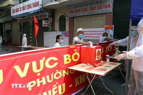 Cử tri tại khu vực bỏ phiếu số 5 - khu vực phong tỏa, cách ly y tế ở phố Hoàng Văn Thụ, phường Trần Phú, thành phố Hải Dương. (Ảnh: Mạnh Tú/TTXVN)