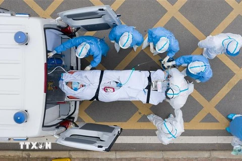 Nhân viên y tế chuyển bệnh nhân COVID-19 tới bệnh viện ở Vũ Hán, tỉnh Hồ Bắc, Trung Quốc. (Ảnh: THX/TTXVN)