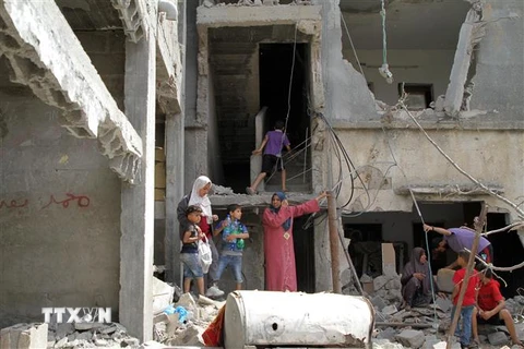 Người dân Palestine trở về bên những căn nhà đã bị phá hủy trong các cuộc không kích của máy bay Israel xuống thị trấn Beit Hanoun, Dải Gaza, khi lệnh ngừng bắn có hiệu lực, ngày 21/5. (Ảnh: THX/TTXVN)