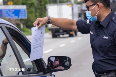 Cảnh sát kiểm tra các phương tiện để phòng dịch COVID-19 tại Petaling Jaya, Malaysia. (Ảnh: THX/TTXVN)