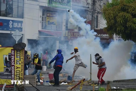 Người biểu tình quá khích đụng độ với cảnh sát tại Cali, Colombia. (Ảnh: AFP/TTXVN)
