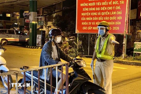 Lực lượng cảnh sát giao thông yêu cầu người dân dừng xe khai báo y tế trên đường Lê Quang Định (phường 1, quận Gò Vấp, Thành phố Hồ Chí Minh). (Ảnh: Hồng Giang/TTXVN)