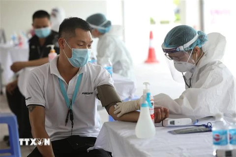 Khám sáng lọc trước khi tiêm vaccine cho công nhân tại Bắc Giang. (Ảnh: Danh Lam/TTXVN)