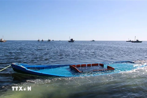 Một chiếc thuyền chở người di cư bị đắm ở ngoài khơi Tunisia được kéo vào gần thị trấn Amra của nước này ngày 13/10/2020. (Ảnh: AFP/TTXVN)