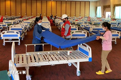 Bố trí giường bệnh bên trong một bệnh viện dã chiến điều trị cho bệnh nhân COVID-19 tại Phnom Penh. (Ảnh: AFP/TTXVN)