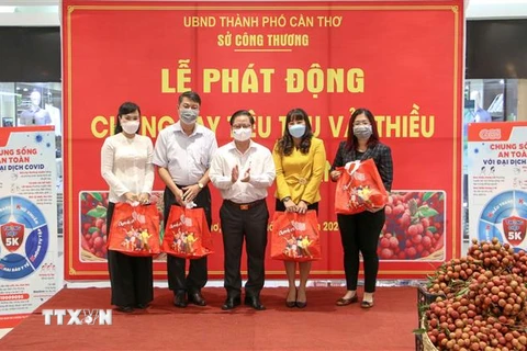 Chủ tịch UBND thành phố Cần Thơ Trần Việt Trường trao các túi vải thiều cho những tổ chức, cá nhân đặt mua đầu tiên tại lễ phát động. (Ảnh: Thanh Liêm/TTXVN)