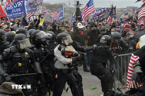 Người biểu tình xung đột với cảnh sát chống bạo động tại Đồi Capitol ở Washington DC., ngày 6/1. (Ảnh: AFP/TTXVN)