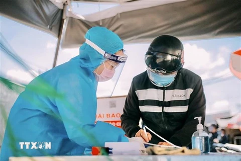 Đoàn viên, thanh niên hỗ trợ người dân khai báo y tế tại Chợ đầu mối Bình Điền (Quận 8, TP.HCM). (Ảnh: Hồng Giang/TTXVN)