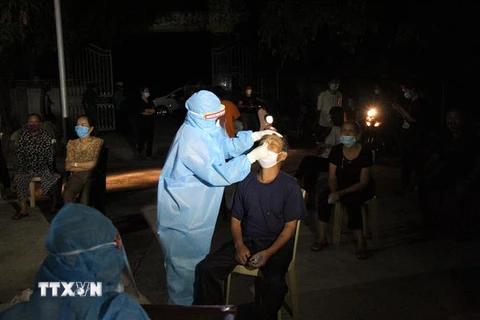 Lực lượng y bác sỹ xuyên đêm lấy mẫu xét nghiệm đối với các trường hợp là F1 của BN11634 ở huyện Diễn Châu, Nghệ An. (Ảnh: Văn Tý/TTXVN)