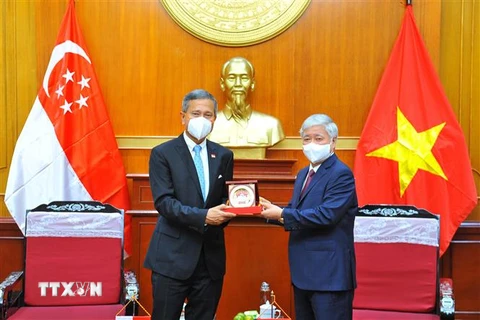 Chủ tịch Ủy ban Trung ương Mặt trận Tổ quốc Việt Nam Đỗ Văn Chiến và Bộ trưởng Bộ Ngoại giao Cộng hòa Singapore Vivian Balakrishnan trao đổi quà lưu niệm. (Ảnh: Minh Đức/TTXVN)