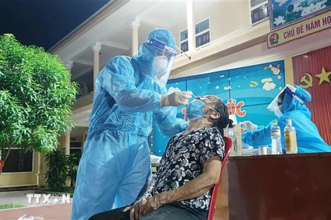 Lực lượng y tế lấy mẫu xét nghiệm COVID-19 cho người dân xã Nghi Ân, thành phố Vinh (Nghệ An). (Ảnh: Văn Tý/TTXVN)
