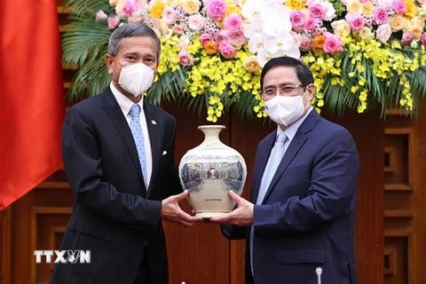 Thủ tướng Phạm Minh Chính tặng quà lưu niệm cho Bộ trưởng Ngoại giao Singapore Vivian Balakrishnan. (Ảnh: Dương Giang/TTXVN)