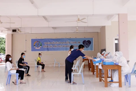 Bác sỹ Lào lấy mẫu xét nghiệm cho sinh viên Việt Nam tại Ký túc xá sinh viên Việt Nam ở thủ đô Vientiane, Lào. (Ảnh: Phạm Kiên/Vietnam+)
