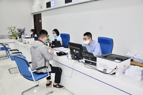 Cán bộ Trung tâm Phục vụ hành chính công tỉnh Quảng Ninh giải quyết thủ tục hành chính cho người dân. (Nguồn: Báo Quảng Ninh)