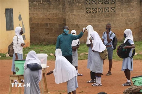 Kiểm tra thân nhiệt của học sinh tại một trường học ở thị trấn Iseyin, bang Oyo, Nigeria. (Ảnh: THX/TTXVN)
