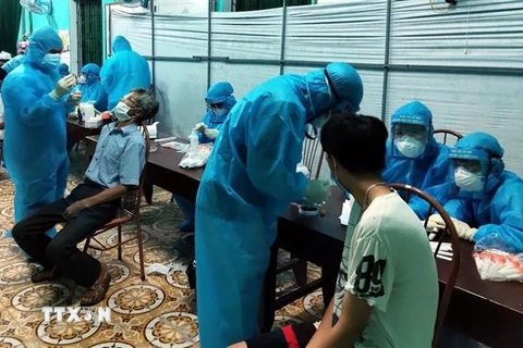Nhân viên y tế lấy mẫu bệnh phẩm ngay trong đêm ở thôn Thanh Mai, xã An Thanh, huyện Quỳnh Phụ. (Ảnh: TTXVN phát)