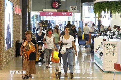 Người dân không phải bắt buộc đeo khẩu trang tại một trung tâm mua sắm ở Tel Aviv, Israel. (Ảnh: AFP/TTXVN)