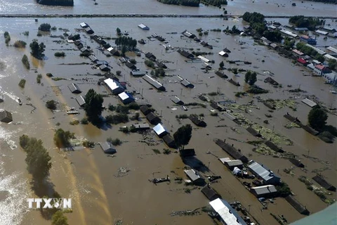 Những ngôi nhà ở thành phố Đồng Giang (Trung Quốc) chìm trong nước lũ do mực nước sông Hắc Long Giang dâng cao. (Ảnh: AFP/TTXVN)