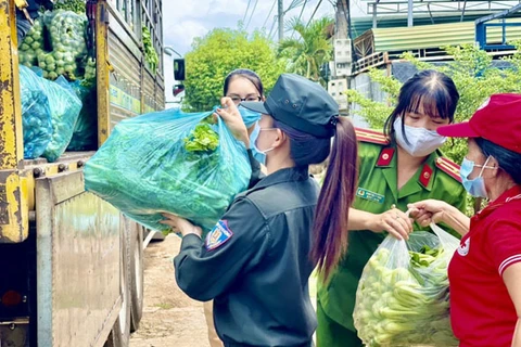 Các thành viên Hội Phụ nữ Công an tỉnh Đắk Lắk và Hội Chữ thập Đỏ thành phố Buôn Ma Thuột tập kết rau xanh để chuyển đến Thành phố Hồ Chí Minh. (Nguồn: baodaklak.vn)