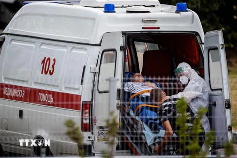 Nhân viên y tế chuyển bệnh nhân COVID-19 từ xe cứu thương vào một bệnh viện ở Moskva, Nga. (Ảnh: AFP/TTXVN)