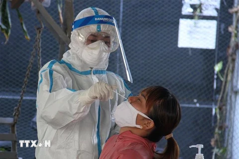 Nhân viên y tế lấy mẫu xét nghiệm tiểu thương chợ Hòa Cầm, Đà Nẵng. (Ảnh: Văn Dũng/TTXVN)