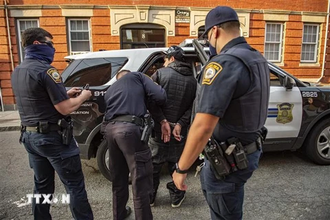Cảnh sát Mỹ khám xét bắt giữ một nghi phạm. (Ảnh: AFP/TTXVN)