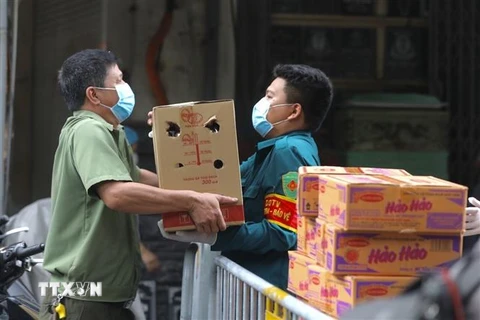 Lực lượng chức năng phường Lý Thái Tổ (quận Hoàn Kiếm) vận chuyển mỳ tôm và trứng hỗ trợ các hộ trong khu vực phong tỏa tạm thời. (Ảnh: Minh Quyết/TTXVN)