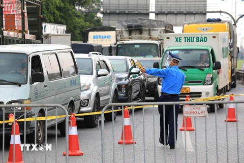 Lực lượng chức năng tại chốt cao tốc Hà Nội-Lạng Sơn (chân cầu Phù Đổng) yêu cầu các tài xế xuống xe để kiểm tra và khai báo y tế. (Ảnh: Thành Đạt/TTXVN)