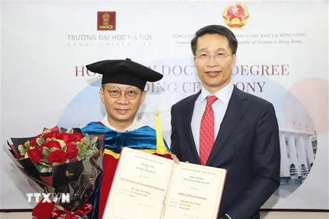Tổng Lãnh sự Việt Nam tại Hong Kong Phạm Bình Đàm (phải) thay mặt Trường Đại học Hà Nội trao bằng Tiến sỹ danh dự cho ông Lâm Kiến Trung, Chủ tịch Tập đoàn Zhang Yang Group HoldingsLtd Hong Kong. (Ảnh: TTXVN)