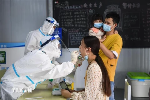 Nhân viên y tế lấy mẫu xét nghiệm COVID-19 cho người dân tại thành phố Nam Kinh, tỉnh Giang Tô, Trung Quốc. (Ảnh: THX/TTXVN)