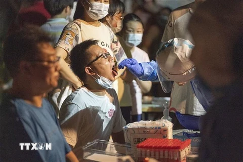 Nhân viên y tế lấy mẫu xét nghiệm COVID-19 cho người dân tại Vũ Hán, tỉnh Hồ Bắc, Trung Quốc. (Ảnh: THX/TTXVN)