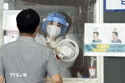 Nhân viên y tế lấy mẫu xét nghiệm COVID-19 cho người dân tại Soeul, Hàn Quốc. (Ảnh: Kyodo/TTXVN)