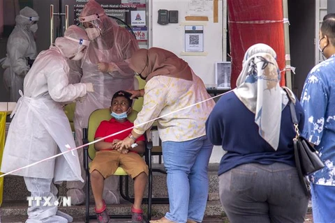 Nhân viên y tế lấy mẫu xét nghiệm COVID-19 tại bang Selangor, Malaysia. (Ảnh: THX/TTXVN)