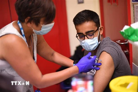 Nhân viên y tế tiêm vaccine ngừa COVID-19 cho người dân. (Ảnh: AFP/TTXVN)