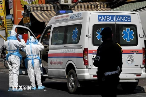 Nhân viên y tế và xe cứu thương được huy động để chuyển bệnh nhân COVID-19 tại Phnom Penh, Campuchia. (Ảnh: AFP/TTXVN)