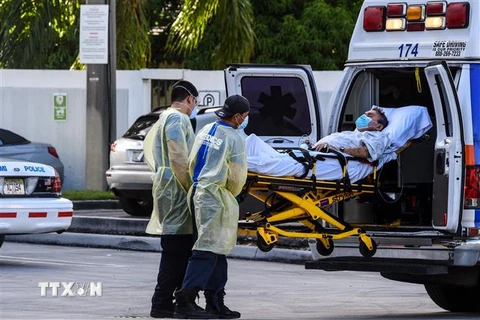 Nhân viên y tế chuyển bệnh nhân COVID-9 từ xe cứu thương vào một bệnh viện ở Miami, bang Florida, miền Nam nước Mỹ. (Ảnh: AFP/TTXVN)