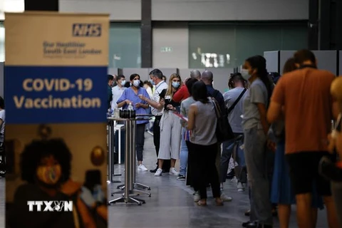 Người dân xếp hàng chờ tiêm vaccine ngừa COVID-19 tại London, Anh. (Ảnh: AFP/TTXVN)