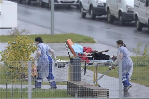Nhân viên y tế chuyển bệnh nhân COVID-19 vào một bệnh viện ở Moskva, Nga. (Nguồn: AFP/TTXVN)