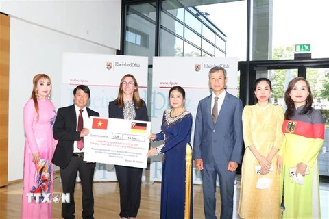 Cộng đồng người Việt tại Đức trao quà tặng cho đại diện bang Rheinland-Pfalz. (Ảnh: Thanh Tùng/TTXVN) 