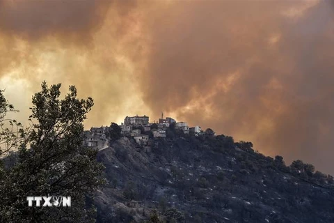 Khói lửa bốc lên trong vụ cháy rừng ở vùng Kabylie thuộc Algeria. (Ảnh: AFP/TTXVN)