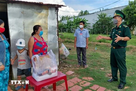Thượng tá Doãn Đình Tránh, Phó Chính ủy Bộ Chỉ huy Bộ đội Biên phòng Kiên Giang, đến thăm, tặng quà bà con vùng biên giới. (Ảnh: TTXVN phát)