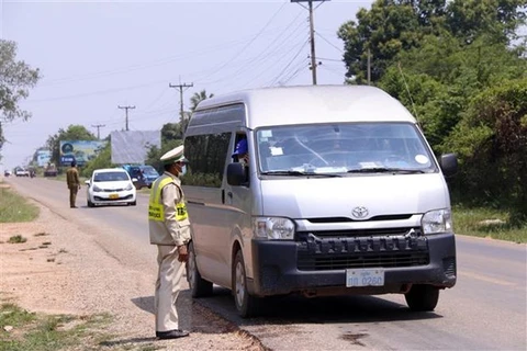 Kiểm tra các phương tiện và người dân khi ra, vào thủ đô Vientiane. (Ảnh: Phạm Kiên/TTXVN)